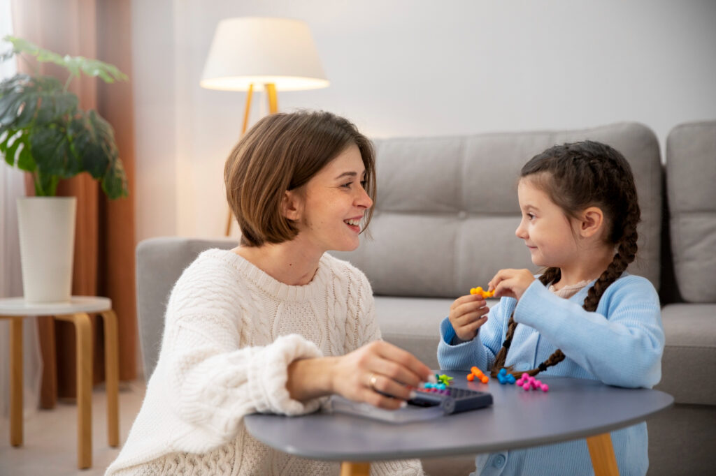 Therapist and kid laughing during a play activity.